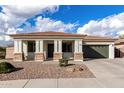 Charming single-story home with a well-maintained front yard and a two-car garage at 18906 E Cattle Dr, Queen Creek, AZ 85142