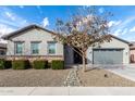 Charming single story home with gray exterior, low maintenance landscaping, and mature shade tree at 21716 E Waverly Dr, Queen Creek, AZ 85142