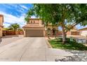 Charming two-story home with a tile roof, stone accents, a well-manicured lawn, and a spacious driveway at 32504 N Cherry Creek Rd, San Tan Valley, AZ 85144