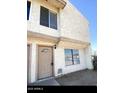 Two-story stucco condo with a brown door and two windows at 3840 N 43Rd Ave # 75, Phoenix, AZ 85031