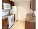 Bright kitchen featuring white appliances and wood cabinets at 3840 N 43Rd Ave # 75, Phoenix, AZ 85031