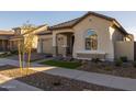 Single story home with a tan stucco exterior, two-car garage, and drought-tolerant landscaping at 4275 E Bernice E St, Gilbert, AZ 85295
