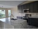 Modern kitchen with dark cabinetry, marble countertops, and stainless steel appliances at 4841 S Vista Pl, Chandler, AZ 85248