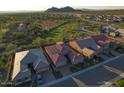 Scenic aerial view of a home featuring a tile roof and solar panels, nestled in a vibrant community with mountain views at 6616 W Side Canyon Trl, Phoenix, AZ 85083