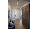 Light-filled entryway with a barn door and hardwood floors at 6616 W Side Canyon Trl, Phoenix, AZ 85083