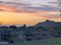 Enjoy breathtaking sunset mountain views from this home's manicured backyard, complete with a secure black iron fence at 6616 W Side Canyon Trl, Phoenix, AZ 85083