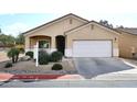 Tan house with white garage door and landscaping at 6657 E Regina St, Mesa, AZ 85215