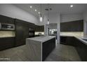 Modern kitchen with dark cabinetry, marble island, and high-end appliances at 10040 N 78Th Pl, Scottsdale, AZ 85258