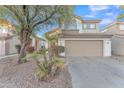 Two-story house with tan exterior, two-car garage, and desert landscaping at 13638 W Desert Flower Dr, Goodyear, AZ 85395