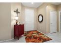 Bright entryway with tiled flooring, red chest, and floral rug at 14982 W Gentle Breeze Way, Surprise, AZ 85374