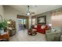 Comfortable living room featuring a red sofa, patterned curtains, and access to a covered patio at 17202 N Javelina Dr, Surprise, AZ 85374