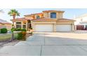 Two-story house with tile roof, three-car garage, and nicely landscaped front yard at 2042 E Victor Rd Rd, Gilbert, AZ 85296