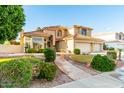 Two-story house with tile roof, three-car garage, and a stone walkway at 2042 E Victor Rd Rd, Gilbert, AZ 85296