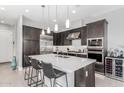 The kitchen features modern dark cabinets, a stainless steel fridge, and a large center island with a sink at 25311 N 19Th Ln, Phoenix, AZ 85085