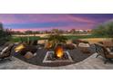 Landscaped backyard with water feature and seating area at 27062 W Behrend Dr, Buckeye, AZ 85396