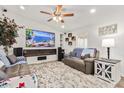 Bright living room with a large TV, fireplace, and comfortable seating at 43459 N Terrace View Ave, San Tan Valley, AZ 85140