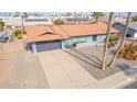 Aerial view of the home featuring a two-car garage, concrete driveway, and desert landscaping at 502 E Le Marche Ave, Phoenix, AZ 85022
