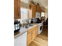 Functional kitchen with wood cabinetry, stainless steel sink, and white appliances at 8700 E University Dr # 1315, Mesa, AZ 85207