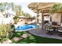 Inviting backyard with a sparkling pool, covered patio, and lush landscaping at 968 W Breckenridge Ave, Gilbert, AZ 85233