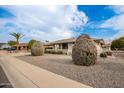 House exterior with a large yard and mature shrubs at 10210 W Charter Oak Dr, Sun City, AZ 85351