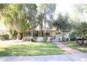 Charming ranch house with a brick walkway and large tree at 1526 W Wilshire Dr, Phoenix, AZ 85007
