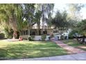 Cute ranch home with brick pathway, lush lawn, and mature trees at 1526 W Wilshire Dr, Phoenix, AZ 85007