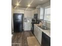 Modern kitchen features gray cabinets, granite countertops, black appliances, and wood-look floors at 625 W Mckellips Rd # 115, Mesa, AZ 85201