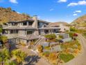 Striking exterior view of a luxurious home with a stone chimney, desert landscaping, and a private driveway at 6850 N 39Th Pl, Paradise Valley, AZ 85253