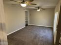 Spacious living room featuring neutral walls, plush carpeting, and ceiling fans at 717 W Chilton St, Chandler, AZ 85225