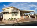 Single-wide manufactured home with covered porch and desert landscaping at 7750 E Broadway Rd # 125, Mesa, AZ 85208