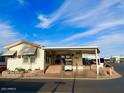 Single-wide manufactured home with covered porch and landscaped yard at 7750 E Broadway Rd # 125, Mesa, AZ 85208