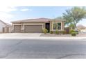 Tan house with a three-car garage and nicely landscaped front yard at 809 W Palo Verde Dr, Casa Grande, AZ 85122
