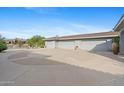 Three-car garage with circular driveway and desert landscaping at 9045 E Chino Dr, Scottsdale, AZ 85255