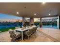 Covered patio with fireplace, outdoor dining, and beautiful desert views near a luxury home pool at 9045 E Chino Dr, Scottsdale, AZ 85255