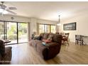 Open-concept living room with wood floors and sliding glass door access to courtyard at 10330 W Thunderbird Blvd # A125, Sun City, AZ 85351