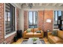 Cozy living room with exposed brick walls and a comfortable leather couch at 114 W Adams St # 807/808, Phoenix, AZ 85003