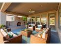 Relaxing covered patio featuring a fireplace and seating area at 12750 W Jasmine Trl, Peoria, AZ 85383