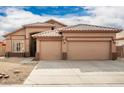 Tan two-story house with a two-car garage and desert landscaping at 15825 W Durango St, Goodyear, AZ 85338