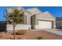 Charming home exterior with tan stucco, a two-car garage, and desert landscaping at 3481 N 309Th Ln, Buckeye, AZ 85396