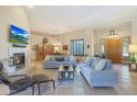 Spacious living room with a fireplace, comfortable seating, and large windows at 4808 N Litchfield E Knl, Litchfield Park, AZ 85340