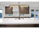 Modern kitchen with white countertops and dark wood cabinets at 6216 W Molly Dr, Phoenix, AZ 85083