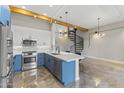 Modern kitchen with blue cabinetry, stainless steel appliances, and a quartz island at 914 E Osborn Rd # 208, Phoenix, AZ 85014