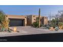 Stucco home with dark garage doors, stone accents, and drought-tolerant landscaping at 10585 E Crescent Moon Dr # 19, Scottsdale, AZ 85262