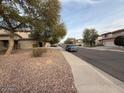 Residential street with houses and desert landscaping at 17322 W Carmen Dr, Surprise, AZ 85388