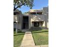 Charming condo complex with landscaped walkway, neutral stucco, and second-story balcony at 1920 W Lindner W Ave # 108, Mesa, AZ 85202