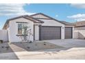 New single-story home with a three-car garage and desert landscaping at 4235 E Brook Lynn Pl, San Tan Valley, AZ 85143