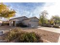 Inviting single-story home with desert landscaping, a spacious driveway, and a two-car garage at 743 E Horizon Heights Dr, San Tan Valley, AZ 85143