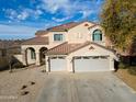 Charming two-story home with a three car garage and a well-maintained front yard on a sunny day at 126 E Key West Dr, Casa Grande, AZ 85122
