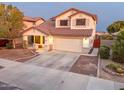 Two-story house with tan exterior, tile roof, and a two-car garage at 15877 W Diamond St, Goodyear, AZ 85338