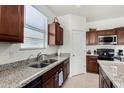 Kitchen boasts granite countertops, double sink, and ample wood cabinetry at 1673 E Jardin Pl, Casa Grande, AZ 85122